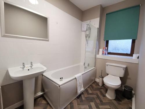 斯特灵Friars Wynd Hotel的一间带水槽、浴缸和卫生间的浴室