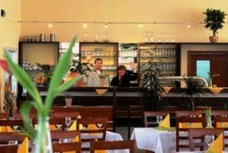 Schemmerhofen楚格恩楚格酒店的两人坐在餐厅柜台