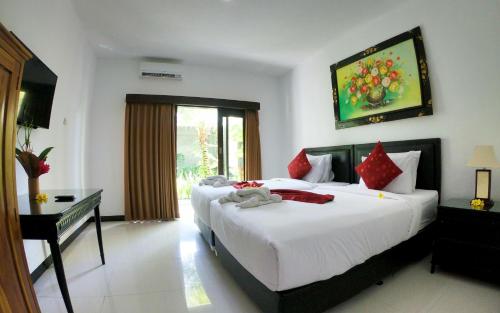 努沙杜瓦棕榈竹酒店的酒店客房配有两张床、一张书桌和一张四柱床。