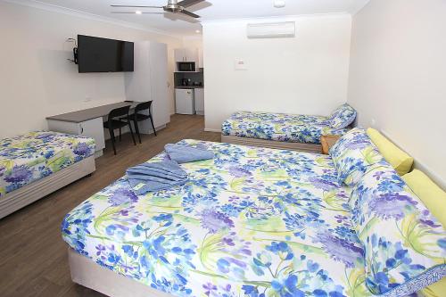 普拉瑟潘礁花园汽车旅馆的一间卧室配有两张床和一张书桌