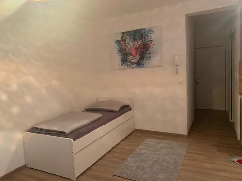 林茨LINZ bellavista Studio-Apartment Landstraße的墙上画作的一张小床