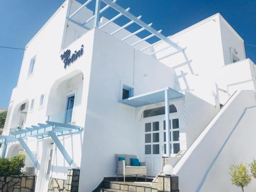 菲罗斯特法尼佛蒂尼别墅酒店的白色的房子,设有蓝色的楼梯和椅子
