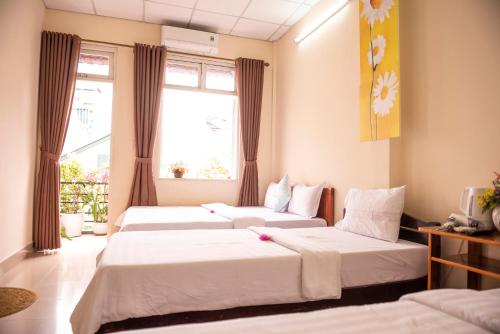 顺化明丹旅馆的带2扇窗户的客房内的2张床