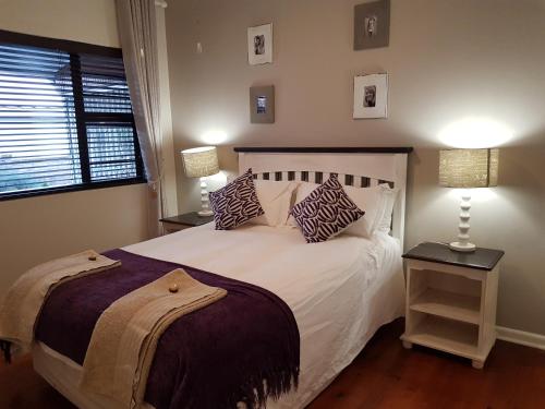 Bushmans River VillageBushys Oak的卧室配有带枕头的白色床和窗户。
