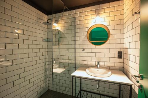 TsinandaliPark Hotel Tsinandali Estate的白色瓷砖浴室设有水槽和镜子