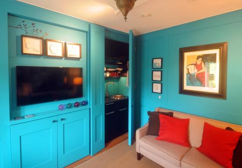 切尔滕纳姆Mulberry cottage的蓝色的客厅配有沙发和电视