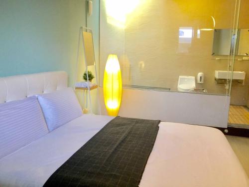 中坜高铁背包客的卧室配有白色的床和灯