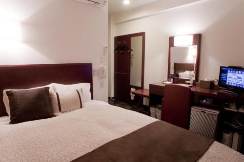 菊川市菊川I.C.吴竹旅馆的一间卧室配有一张床、一张书桌和一台电视
