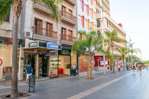圣克鲁斯-德特内里费Hotel Océano Centro的城市里一条拥有商店和棕榈树的城市街道