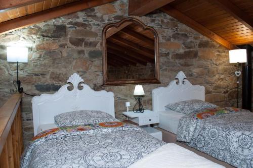 Maljoga de ProençaAzoka by the River- Proença-a-Nova的一间卧室设有两张床和石墙