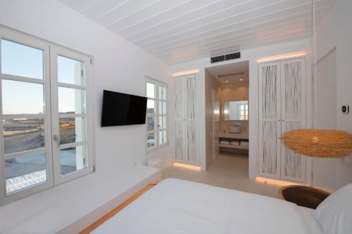 超级天堂海滩The Ammonite Resort的白色的客房配有床和电视