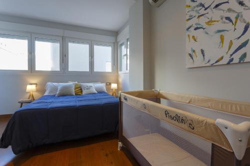 加的斯HORIZONTE Sunny Home by Cadiz4Rentals的一间卧室配有一张带蓝色床单和窗户的床。