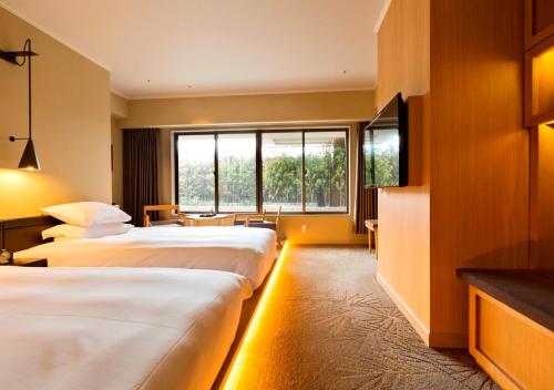 高松高松皇家花园酒店的酒店客房设有两张床和电视。