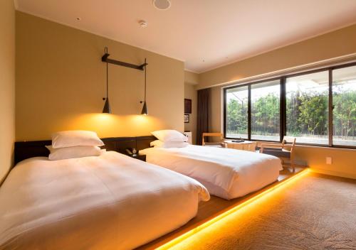 高松高松皇家花园酒店的一间卧室设有两张床和大窗户