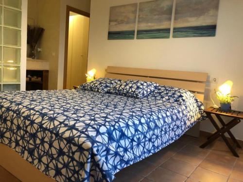 库尼特Casa Bella Vista en montaña con vistas al mar y piscina privada的一间卧室配有一张带蓝色和白色棉被的床