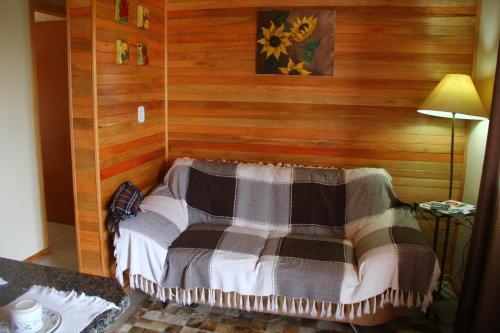 圣若阿金Apartamento Serrano的一间卧室设有木墙和一张带毯子的床