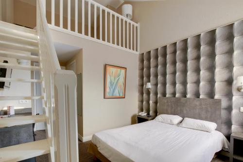 拉尼翁Hôtel Arcadia的一间卧室设有高架床和楼梯。