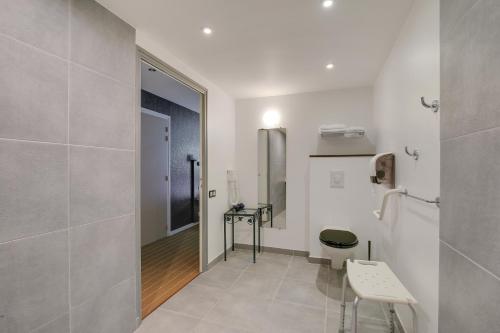拉尼翁Hôtel Arcadia的白色的浴室设有卫生间和镜子