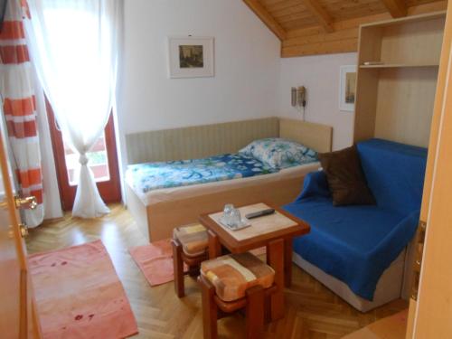 布达佩斯柯索柏金链花旅馆的小房间设有床和蓝色的沙发