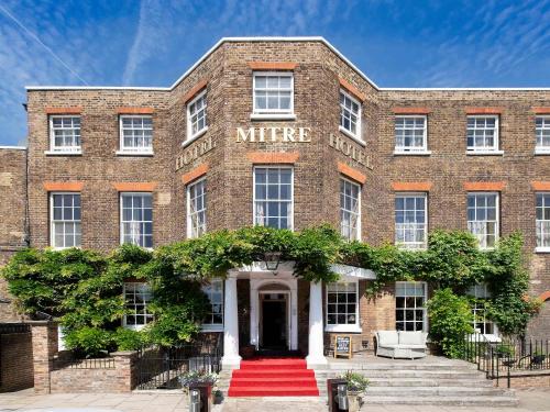 泰晤士河畔金斯顿The Mitre, Hampton Court的一座古老的砖楼,有红地毯入口