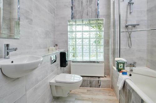 巴利瓦根海兰兹伯伦酒店的浴室配有盥洗盆、卫生间和浴缸。