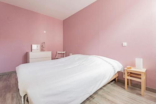 兰斯REIMS LA ROMAINE的卧室设有粉红色的墙壁、一张床和一张桌子