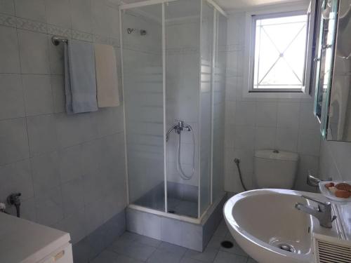 索瓦拉Sun and Sea的带淋浴和盥洗盆的白色浴室