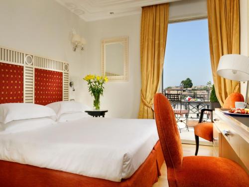 罗马FH55 Grand Hotel Palatino的酒店客房设有一张床和一个阳台。