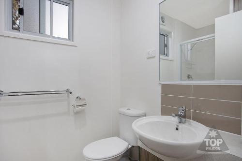霍舍姆霍舍姆河滨大篷车公园露营地的白色的浴室设有卫生间和水槽。
