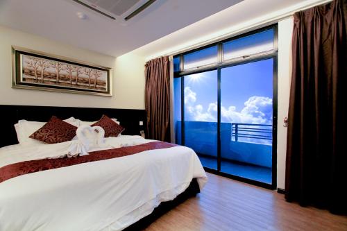 瓜拉丁加奴J套房酒店的一间卧室设有一张床和一个大窗户