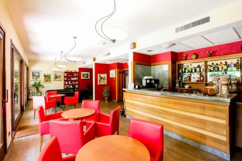 奥斯塔麦尔格酒店的一间设有红色椅子的餐厅和一间酒吧