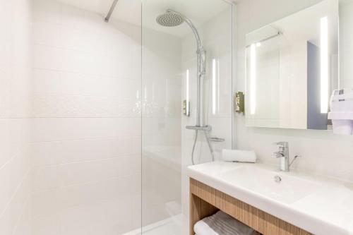 LoosBest Western Le Beffroi的白色的浴室设有水槽和淋浴。