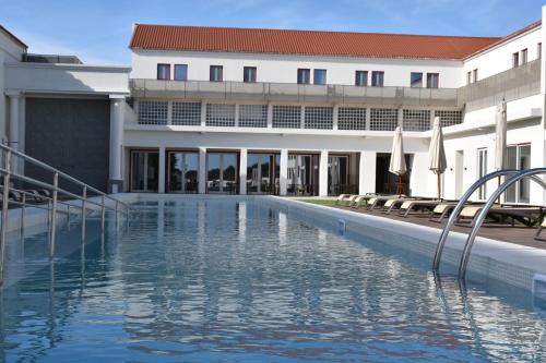 萨尔堡Hotel da Barrosinha的大楼前的游泳池