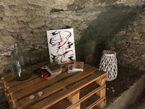 Santa-Lucia-di-Mercurio,A cantinella, une cave a fromage au centre corse的一张木桌,上面有书籍和画