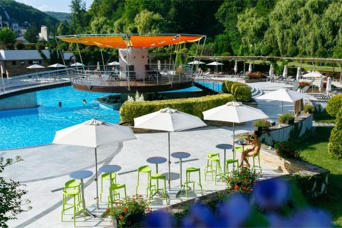 尼日尔索洛维诺Apartament Hotel by Derenivska Kupil的一个带绿色桌椅和遮阳伞的游泳池