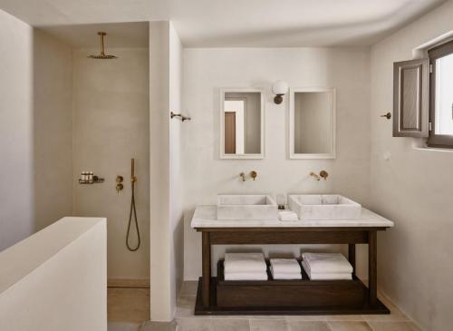 纳乌萨Parilio, a Member of Design Hotels的一间带水槽和两面镜子的浴室