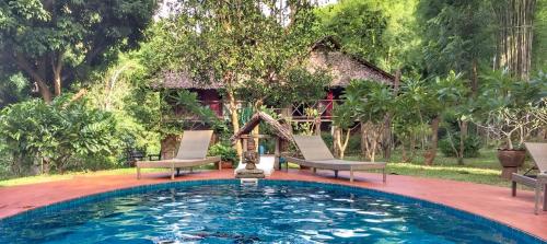湄宏颂桑桐小屋旅馆的房屋前带两把椅子的游泳池