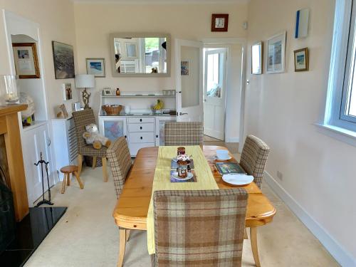 圣安德鲁斯No12 Bed and Breakfast, St Andrews的厨房以及带木桌和椅子的用餐室。