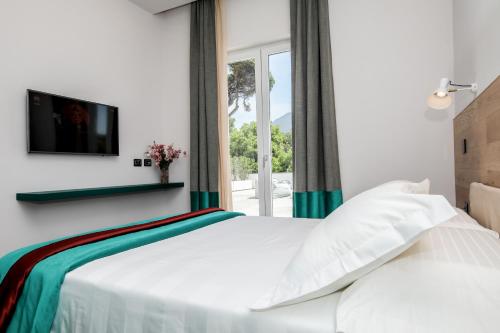 埃尔科拉诺Il San Cristoforo的卧室配有白色的床和窗户。