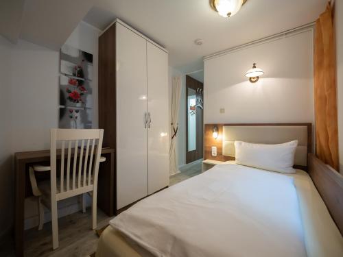 汉堡Hotel Boritzka的卧室配有白色的床和椅子