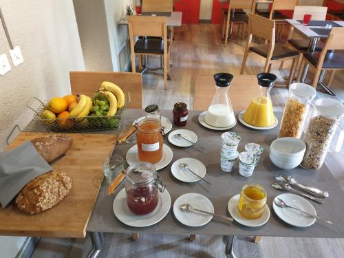 伯韦Hôtel du Cygne的餐桌上放着盘子和一篮水果