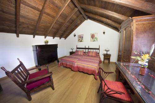 圣巴托洛梅Casa rural en Hoya de Tunte 3的一间带一张床的卧室,位于带木制天花板的房间内