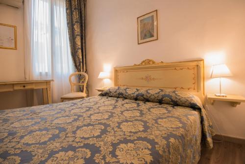 威尼斯阿尔伯格卡萨庇隆酒店的一间卧室配有一张带蓝色棉被的床