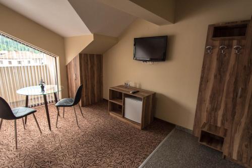 埃特罗波莱Etobicoke -Стаи за гости的一间设有桌子和墙上电视的房间