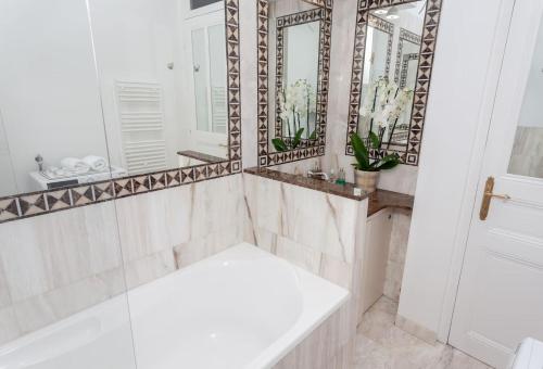 博索莱伊Charmant 2 pieces frontiere Monaco的浴室配有白色浴缸和镜子