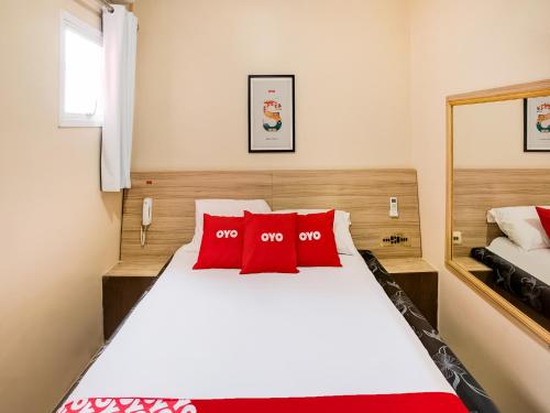 圣保罗OYO Hotel Itarantim, São Paulo的卧室配有带红色枕头的大型白色床