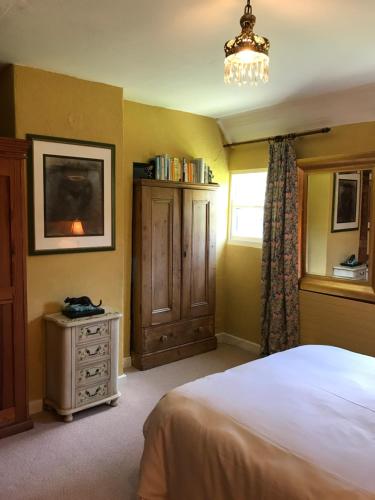 博里斯Corriebeg Cottage的一间卧室配有一张床、一个梳妆台和一扇窗户。