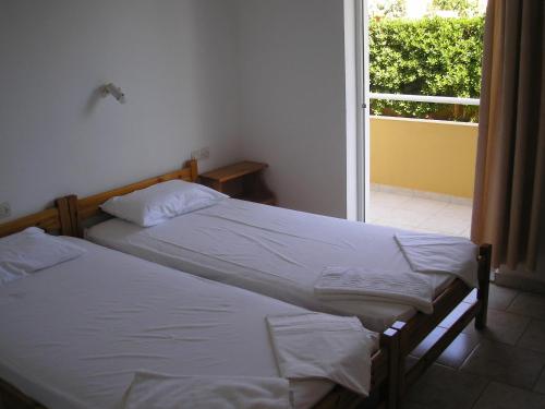 古瓦伊Dimitra Apartments的带窗户的客房内设有两张单人床。