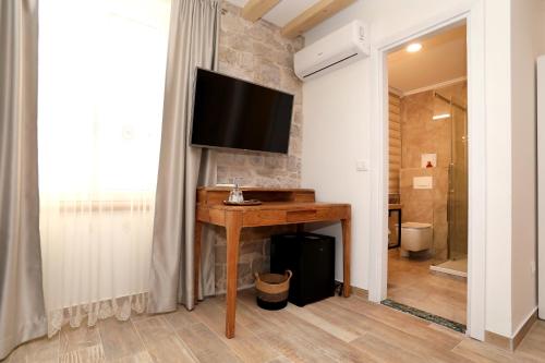 特罗吉尔Villa Teuta的浴室设有一张桌子,墙上配有电视