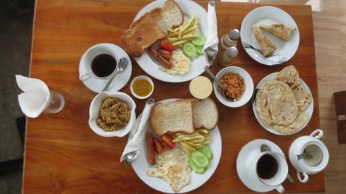 阿鲁甘湾Green Ocean Bay的一张木桌,上面放着早餐食品